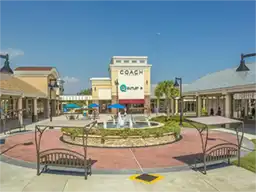 Outdoor shopping mall courtyard with a central fountain