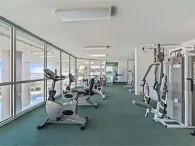 Bright, spacious fitness room with cardio machines and full-height windows