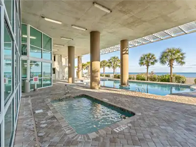 Covered oceanfront pool and hot tub with beautiful palm-lined views