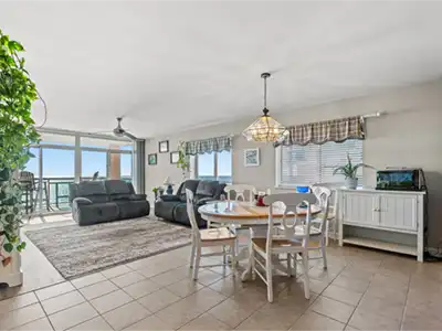 Bright coastal living space with ocean views and balcony access