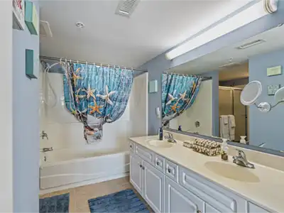 Spacious coastal-style bathroom with double vanity and tub/shower combo