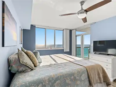 Sunny ocean-view bedroom with balcony access and serene coastal style