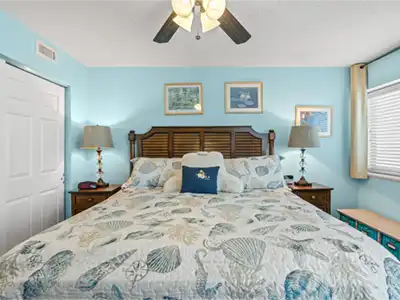 Coastal king bedroom with bright blue walls and breezy beach-inspired decor