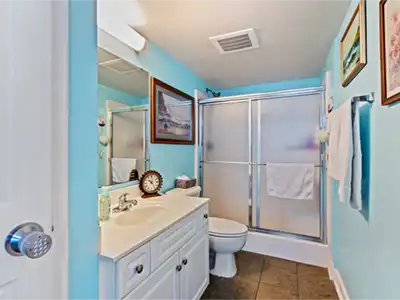 Bright blue bathroom with frosted glass shower and stylish vanity